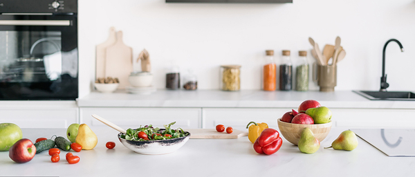 A bright kitchen counter with bowls of fresh produce ready for a simple meal